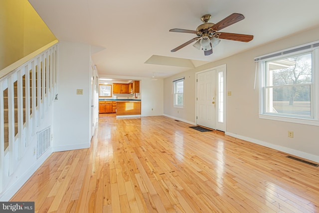 unfurnished living room with ceiling fan and light hardwood / wood-style floors