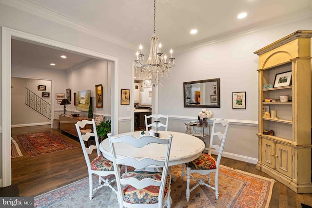 dining area with dark hardwood / wood-style floors, an inviting chandelier, and ornamental molding