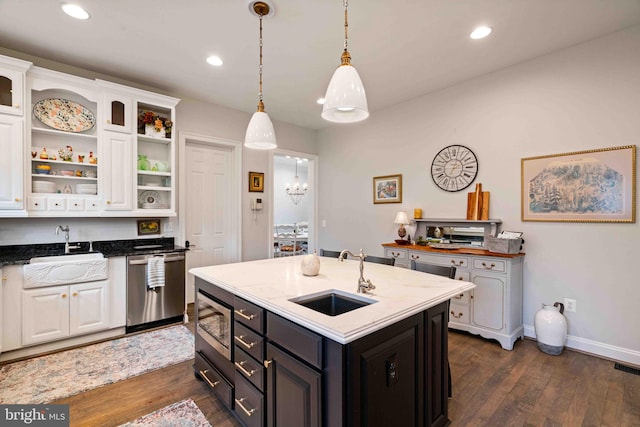 kitchen featuring white cabinets, decorative light fixtures, an island with sink, and appliances with stainless steel finishes