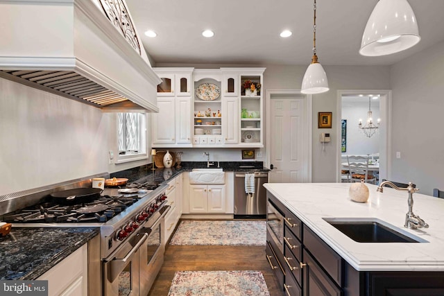 kitchen featuring sink, white cabinetry, premium range hood, and appliances with stainless steel finishes