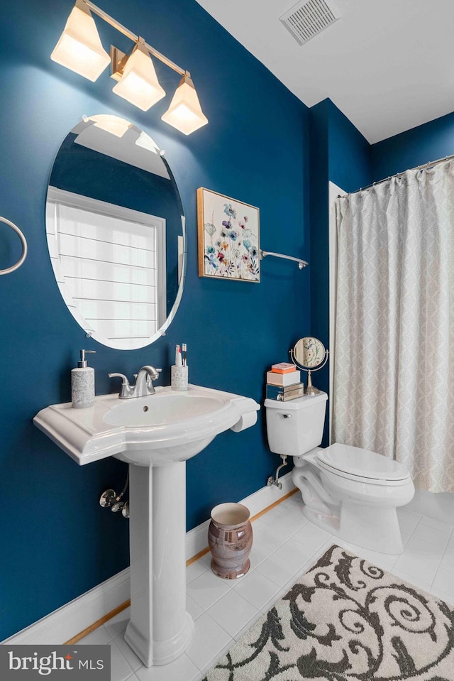 bathroom with tile patterned floors, toilet, and walk in shower