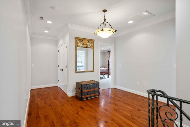 corridor featuring ornamental molding and hardwood / wood-style flooring