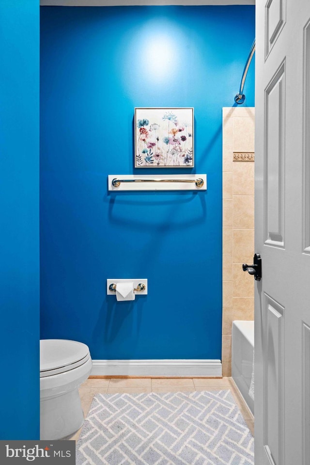 bathroom featuring tile patterned floors, toilet, and washtub / shower combination