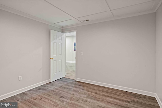 empty room featuring hardwood / wood-style floors and crown molding