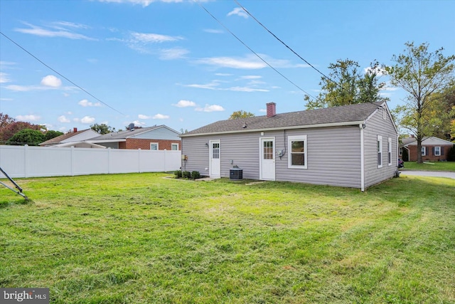 rear view of property with a lawn and central AC unit