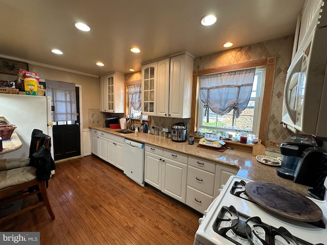 kitchen featuring white appliances, crown molding, dark hardwood / wood-style flooring, white cabinets, and sink