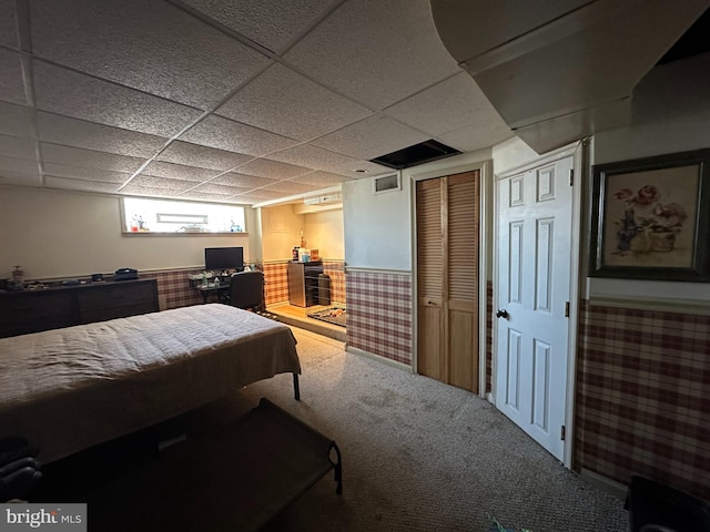 bedroom with carpet floors and a drop ceiling