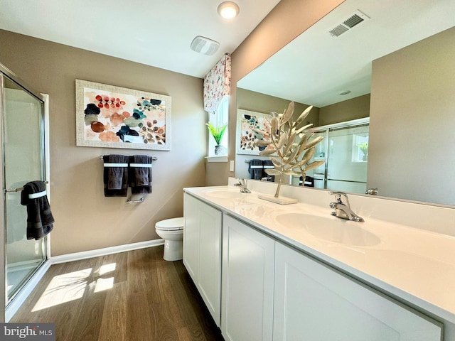 bathroom featuring vanity, toilet, a shower with shower door, and hardwood / wood-style flooring