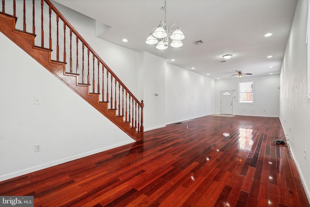 unfurnished living room with wood-type flooring and ceiling fan with notable chandelier