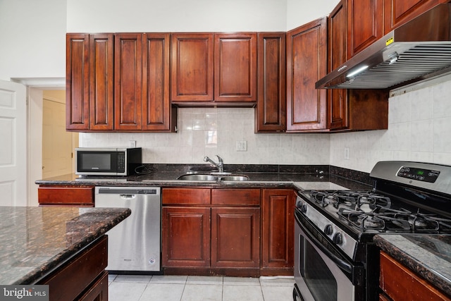 kitchen featuring decorative backsplash, dark stone countertops, exhaust hood, and stainless steel appliances