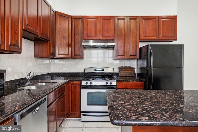 kitchen with sink, dishwasher, black fridge, white range with gas stovetop, and dark stone counters