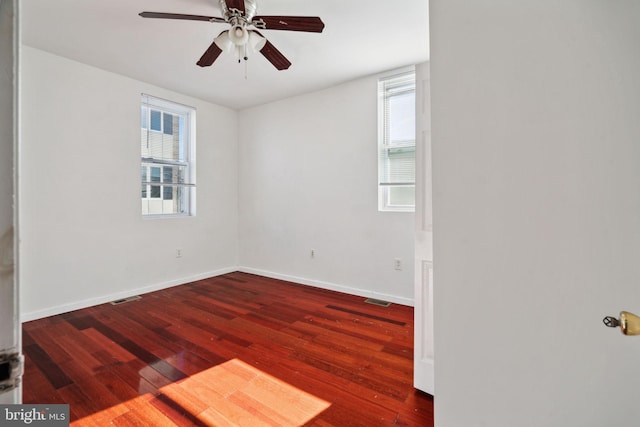 unfurnished room with dark hardwood / wood-style floors, plenty of natural light, and ceiling fan