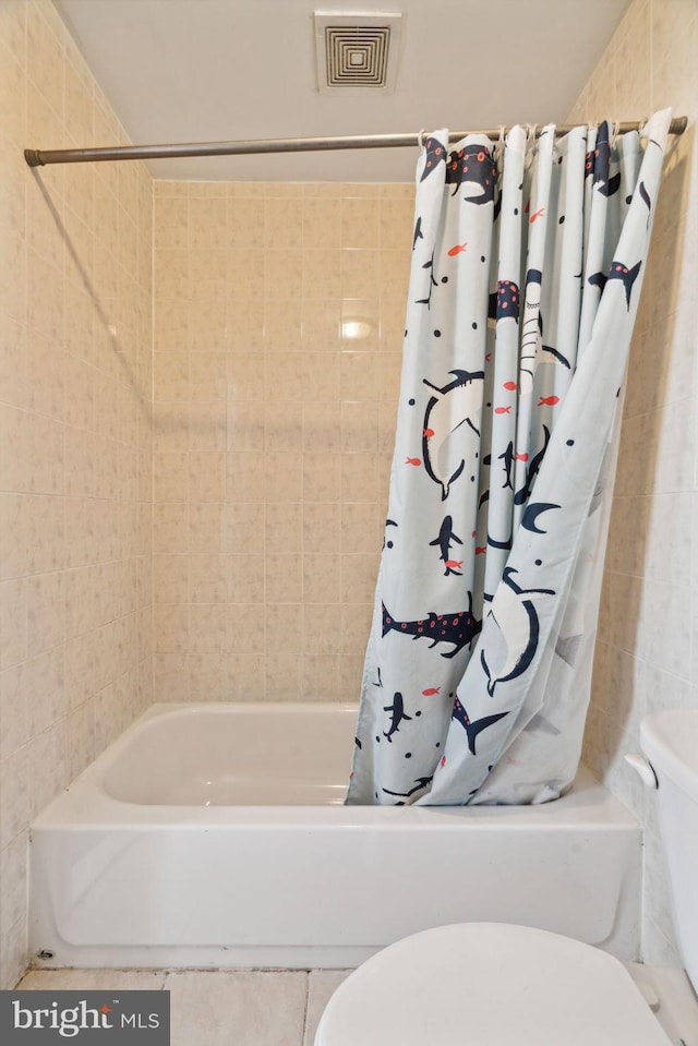 bathroom featuring shower / tub combo with curtain and tile walls