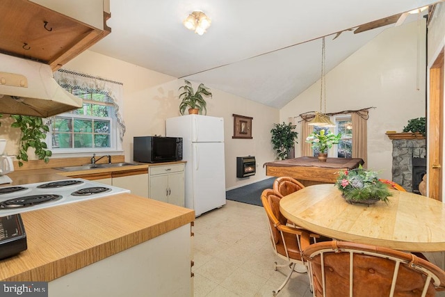 kitchen with sink, lofted ceiling, white appliances, a fireplace, and white cabinets