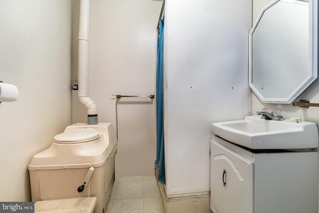 full bath with toilet, vanity, and baseboards