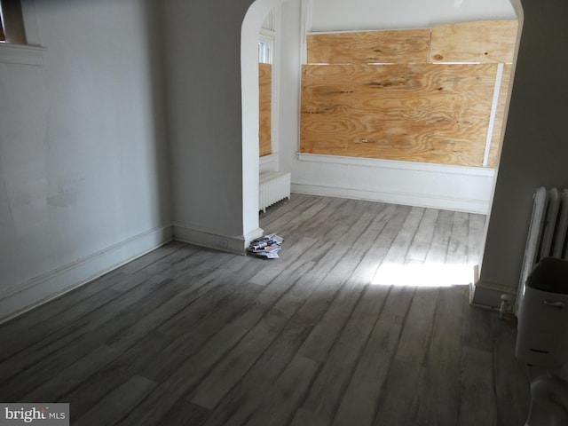 unfurnished room with dark hardwood / wood-style floors and radiator