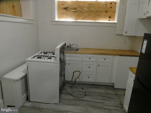 laundry room with light wood-type flooring and sink