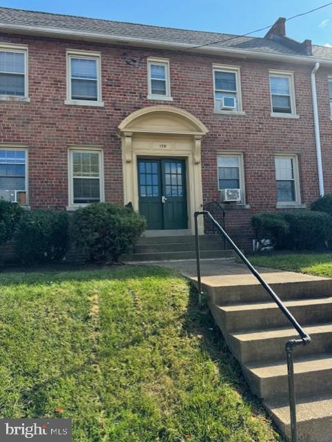 view of property with a front lawn, cooling unit, and french doors