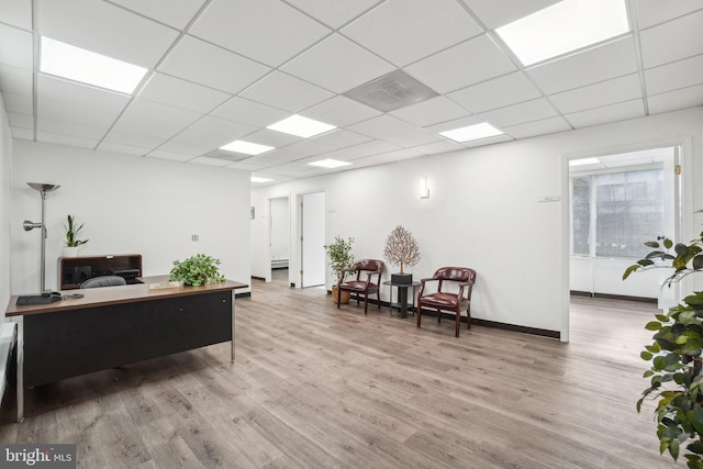 office area featuring a paneled ceiling and hardwood / wood-style flooring