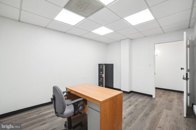 home office featuring hardwood / wood-style floors and a paneled ceiling