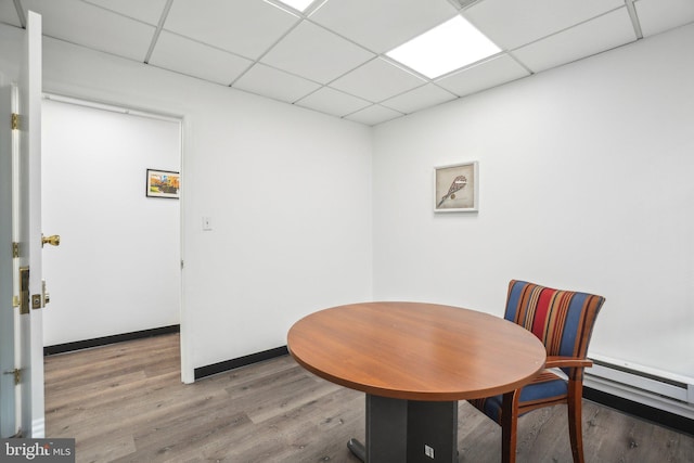 dining space featuring a paneled ceiling and hardwood / wood-style flooring