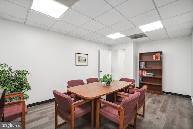 dining space featuring a paneled ceiling and light wood-type flooring