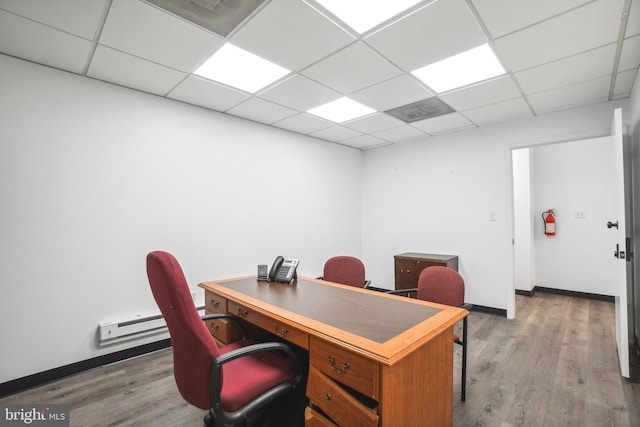 office space featuring a paneled ceiling and light wood-type flooring