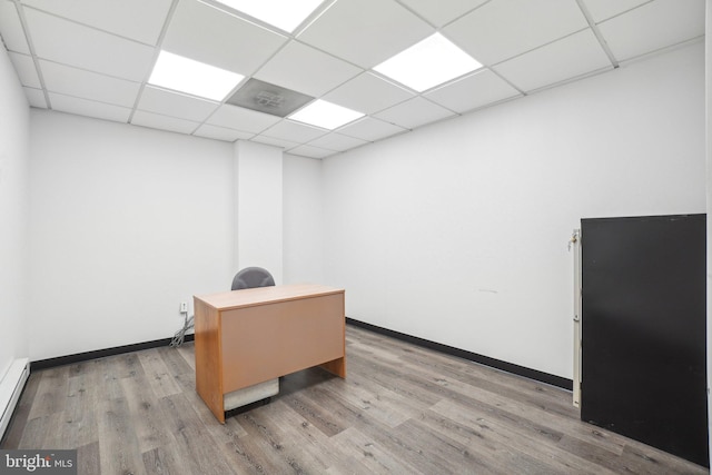 office area with a paneled ceiling, light hardwood / wood-style flooring, and a baseboard radiator