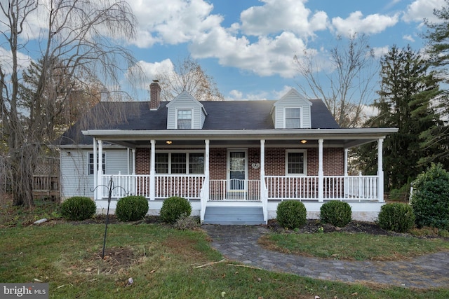 cape cod-style house with covered porch