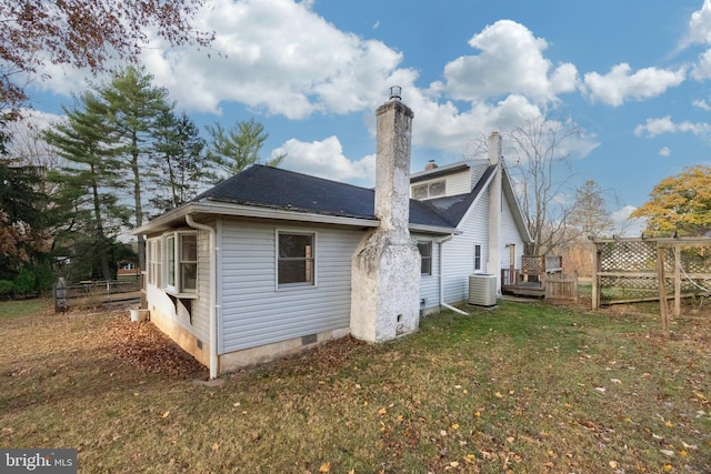 back of property featuring a lawn and cooling unit