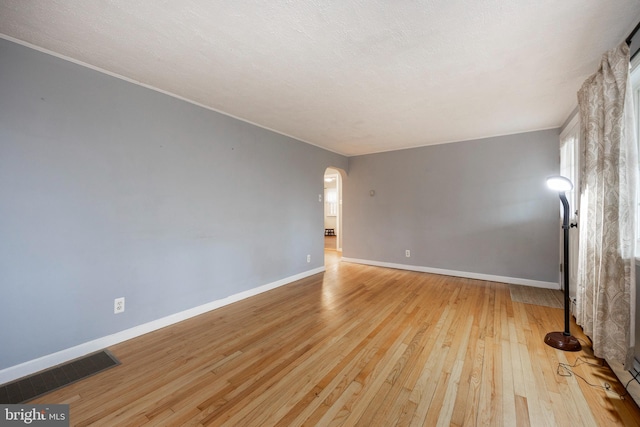 unfurnished living room featuring a textured ceiling and light hardwood / wood-style flooring