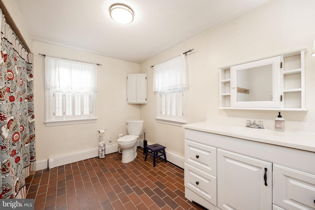 bathroom featuring plenty of natural light, toilet, vanity, and a baseboard radiator