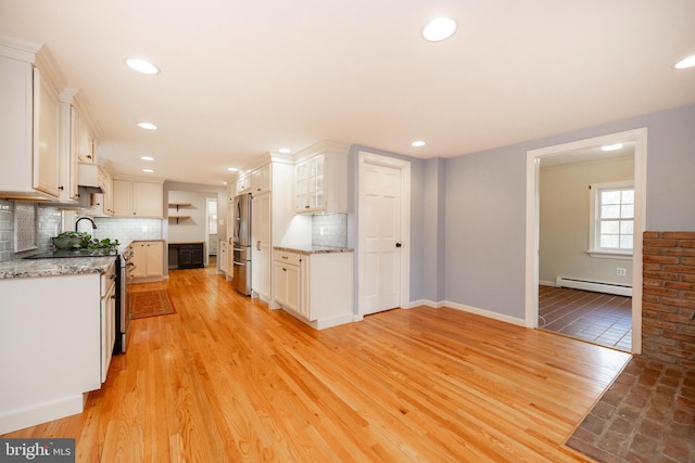 kitchen featuring light wood-type flooring, white cabinetry, and baseboard heating