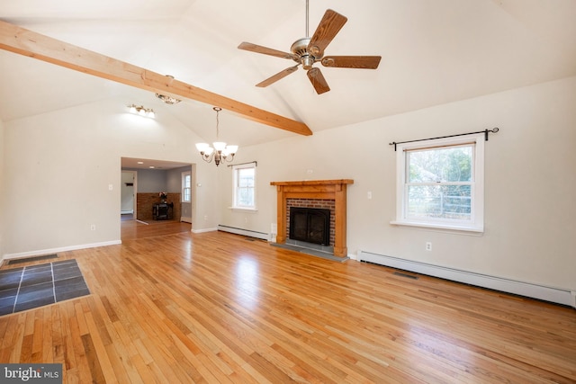 unfurnished living room featuring vaulted ceiling with beams, a baseboard heating unit, a wealth of natural light, and light hardwood / wood-style flooring