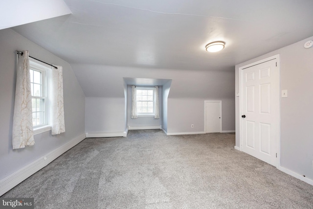 bonus room with carpet, vaulted ceiling, and a baseboard heating unit