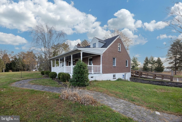 view of side of property with a porch and a lawn