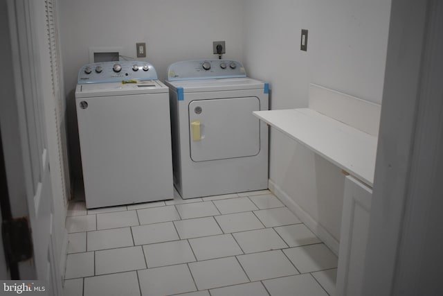 laundry area with light tile patterned flooring and separate washer and dryer