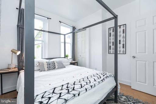 bedroom with dark hardwood / wood-style flooring and a closet