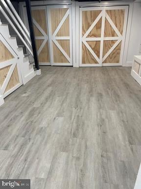 interior space with a barn door and hardwood / wood-style flooring