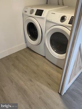 washroom featuring independent washer and dryer and hardwood / wood-style flooring