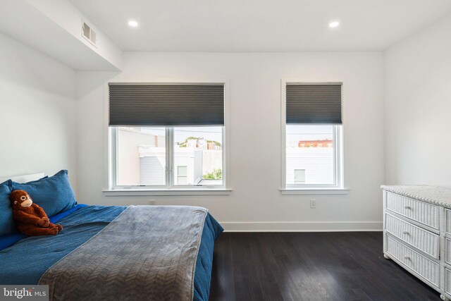 bedroom with dark hardwood / wood-style flooring and multiple windows