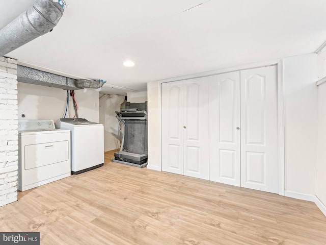 clothes washing area with separate washer and dryer and light wood-type flooring