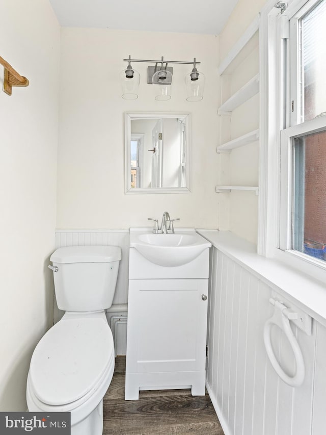 bathroom with hardwood / wood-style floors, vanity, and toilet