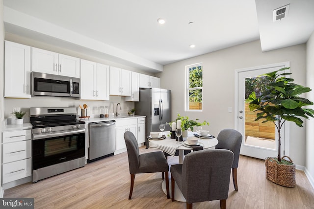 2714 Cecil B Moore Ave, Philadelphia, PA 19121 - kitchen with stainless steel appliances, light wood-type flooring, white cabinets, recessed lighting, and light countertops