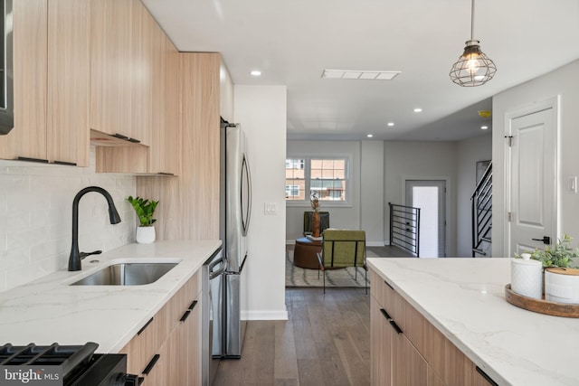 kitchen with dark wood-type flooring, sink, decorative backsplash, light stone counters, and stainless steel appliances