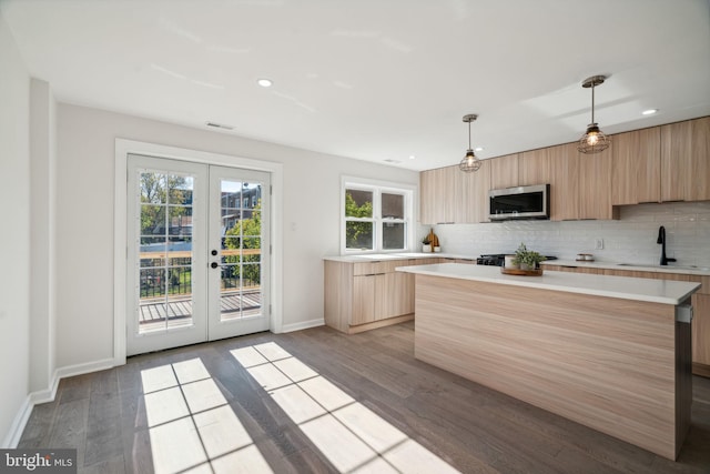 kitchen with appliances with stainless steel finishes, light wood-type flooring, french doors, and pendant lighting