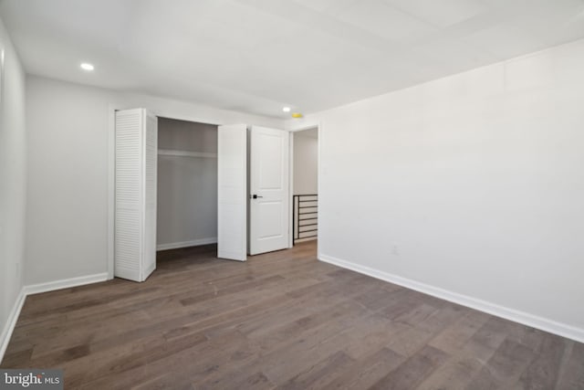 unfurnished bedroom with dark hardwood / wood-style floors and a closet