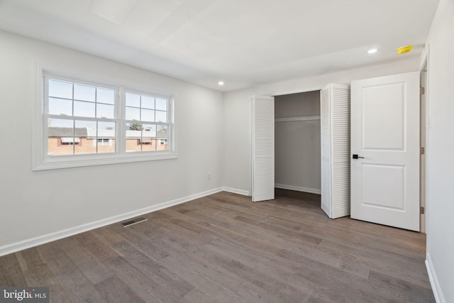 unfurnished bedroom with hardwood / wood-style floors and a closet