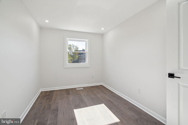 spare room with dark hardwood / wood-style flooring