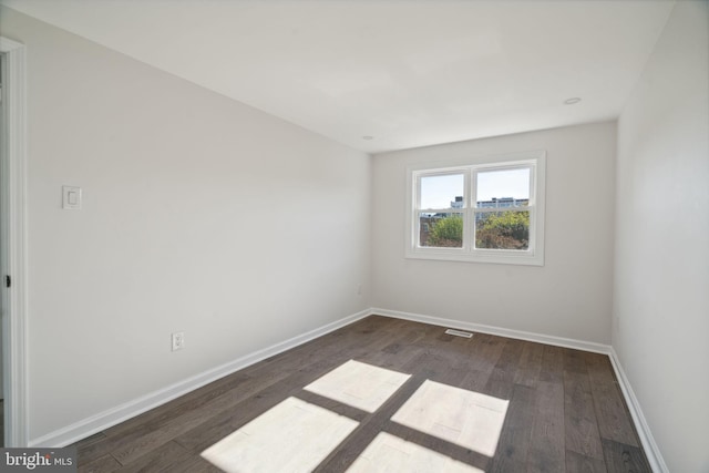 empty room with dark hardwood / wood-style flooring